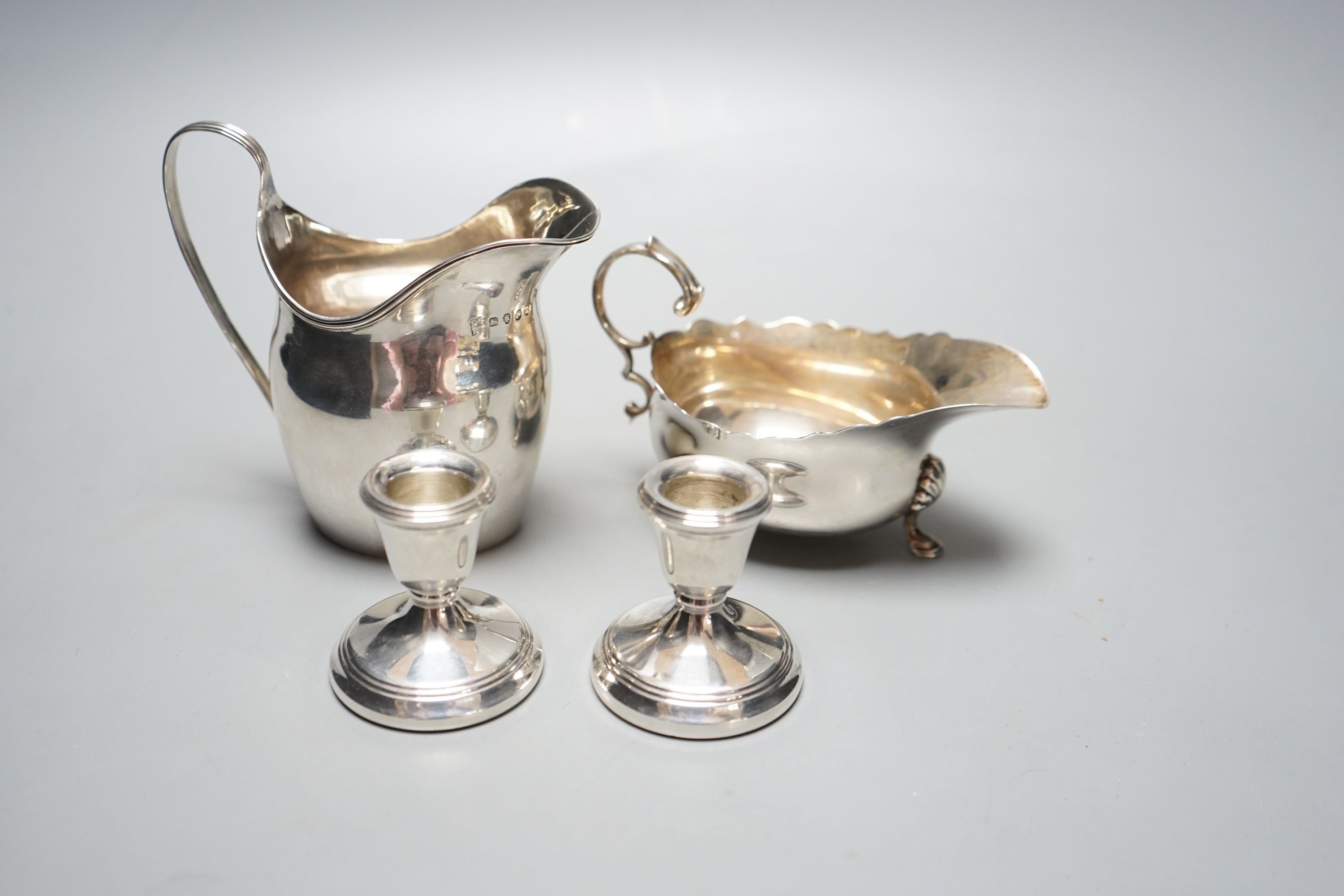 A George III silver jug, London, 1798, a silver sauce boat and pair of silver mounted dwarf candlesticks.